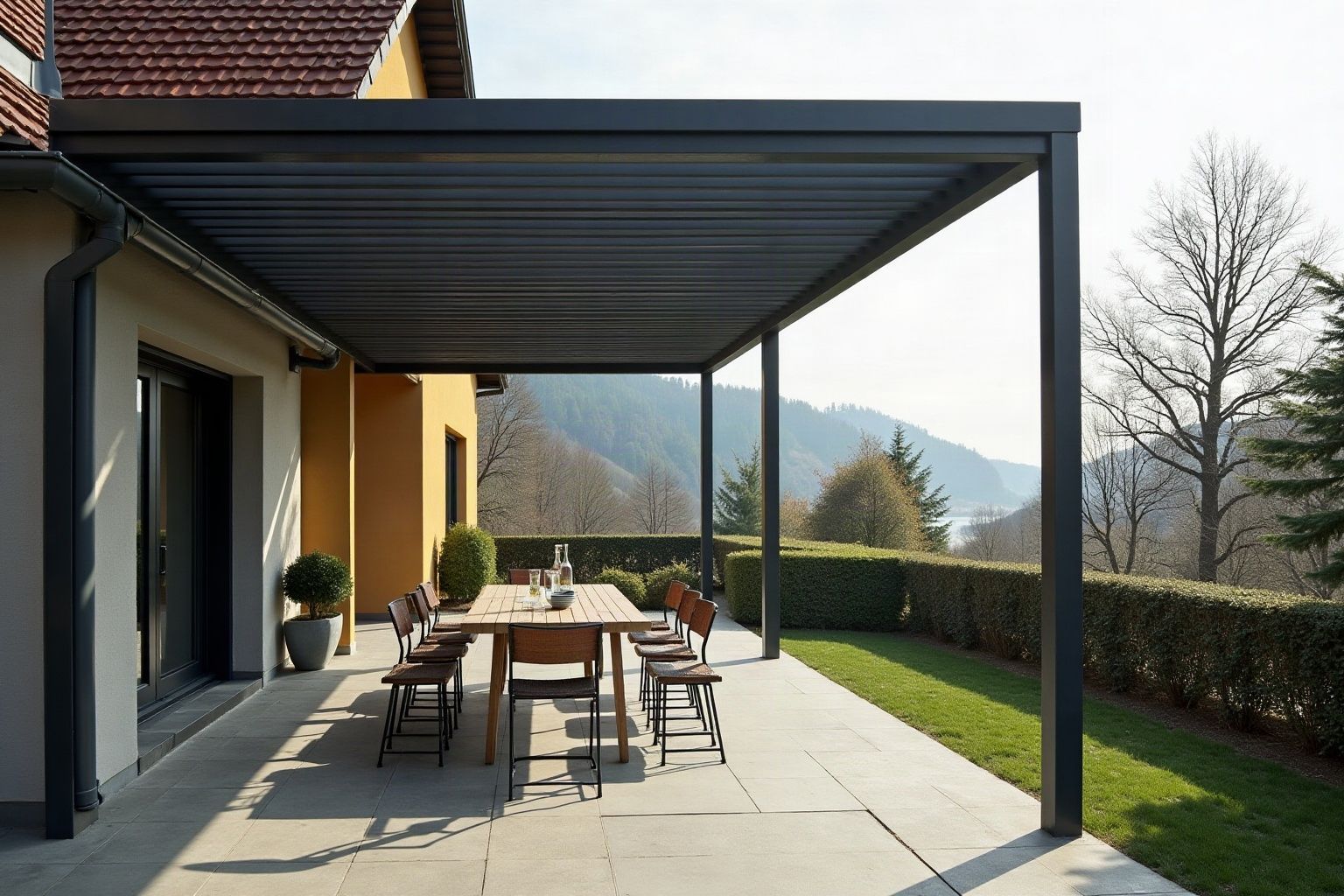 Pergola bioclimatique en aluminium anthracite à lames orientables sur une terrasse